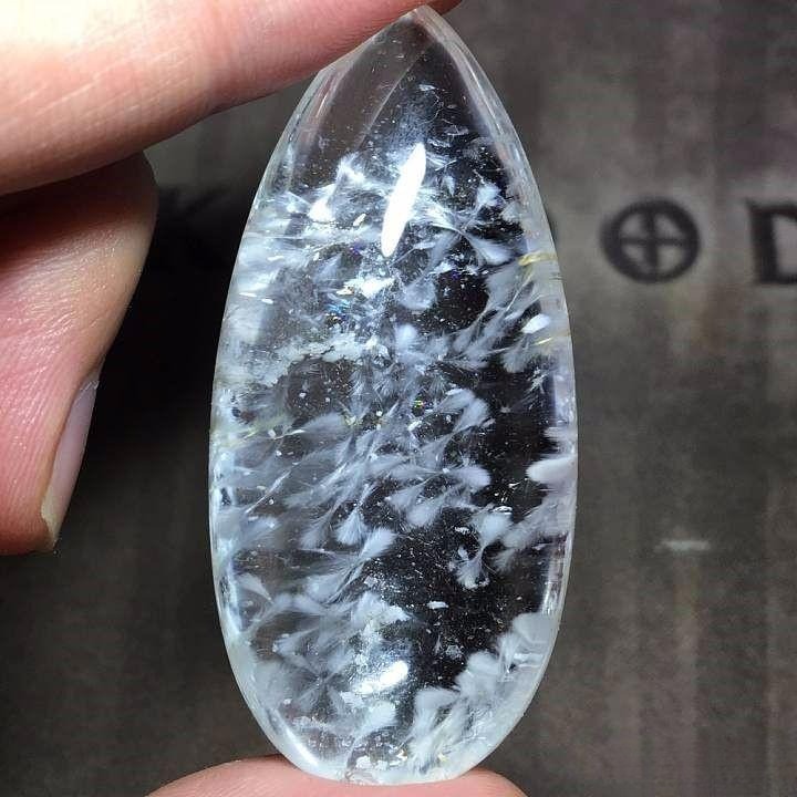 Fibrous calcite floating like delicate feathers inside clear quartz
