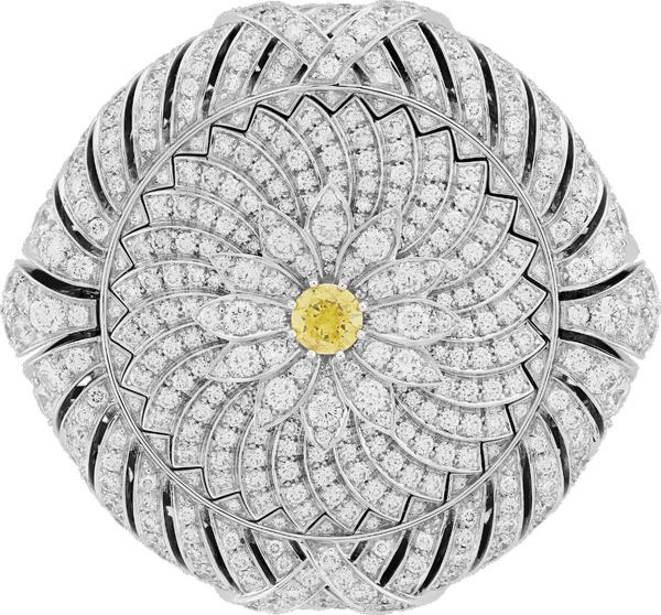 Close-up of a flower-shaped jewelry piece featuring a yellow gemstone at its center, highlighting its delicate design