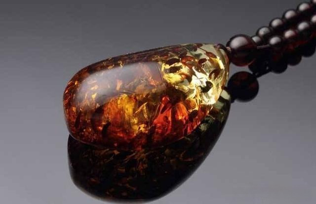 Flower-pattern amber pendant necklace, featuring beads where internal micro-bubbles burst from heat treatment, creating flower or sun-ray designs inside the amber.