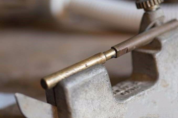 Securing the gemstone in a horizontal position with the bottom point facing upwards, preparing for precise cutting