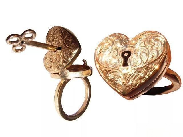Heart-shaped metal ring with hidden compartment opened to reveal secret storage, showcasing mechanical jewelry craftsmanship.