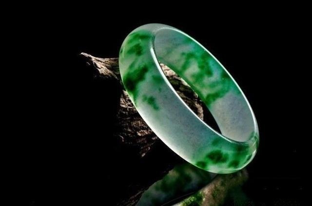 Jade bangle with flowering effect, showcasing beautiful color patterns and dynamic jadeite texture.