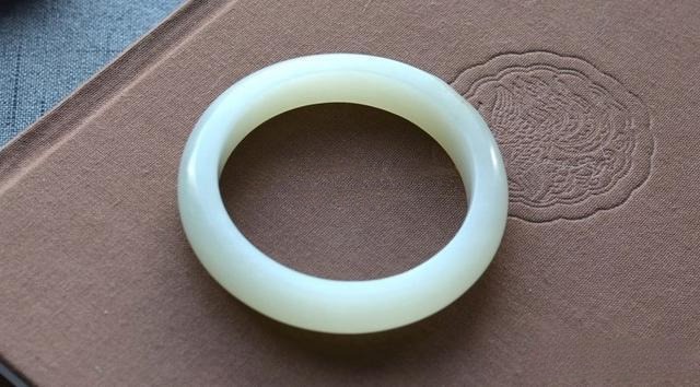 Custom Jewea bangle made from aged Xinjiang Hetian jade seed material.