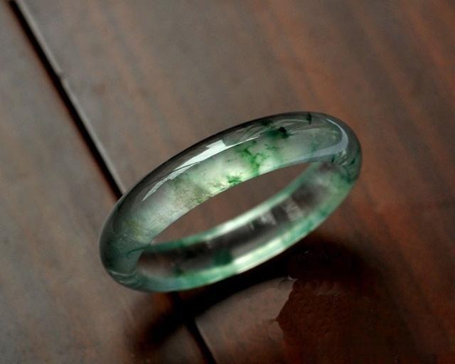 Jewea jade bangle, showcasing dynamic color patterns and exquisite jadeite craftsmanship, highlighting the beauty of jadeite color foundation.