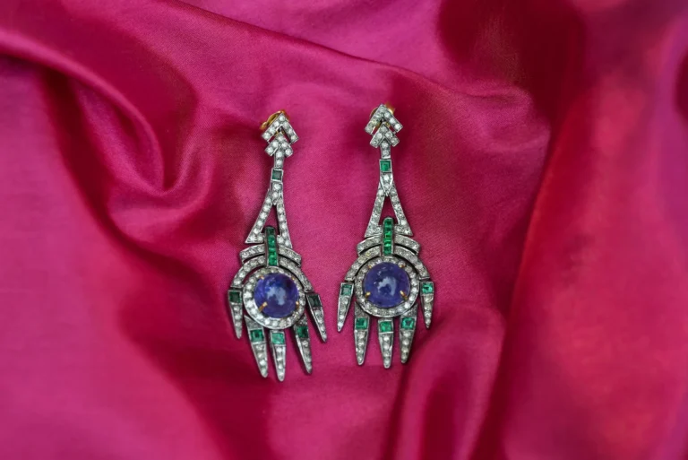 Close-up of luxury earrings with Madagascar and Sri Lanka pink sapphires on vibrant silk background