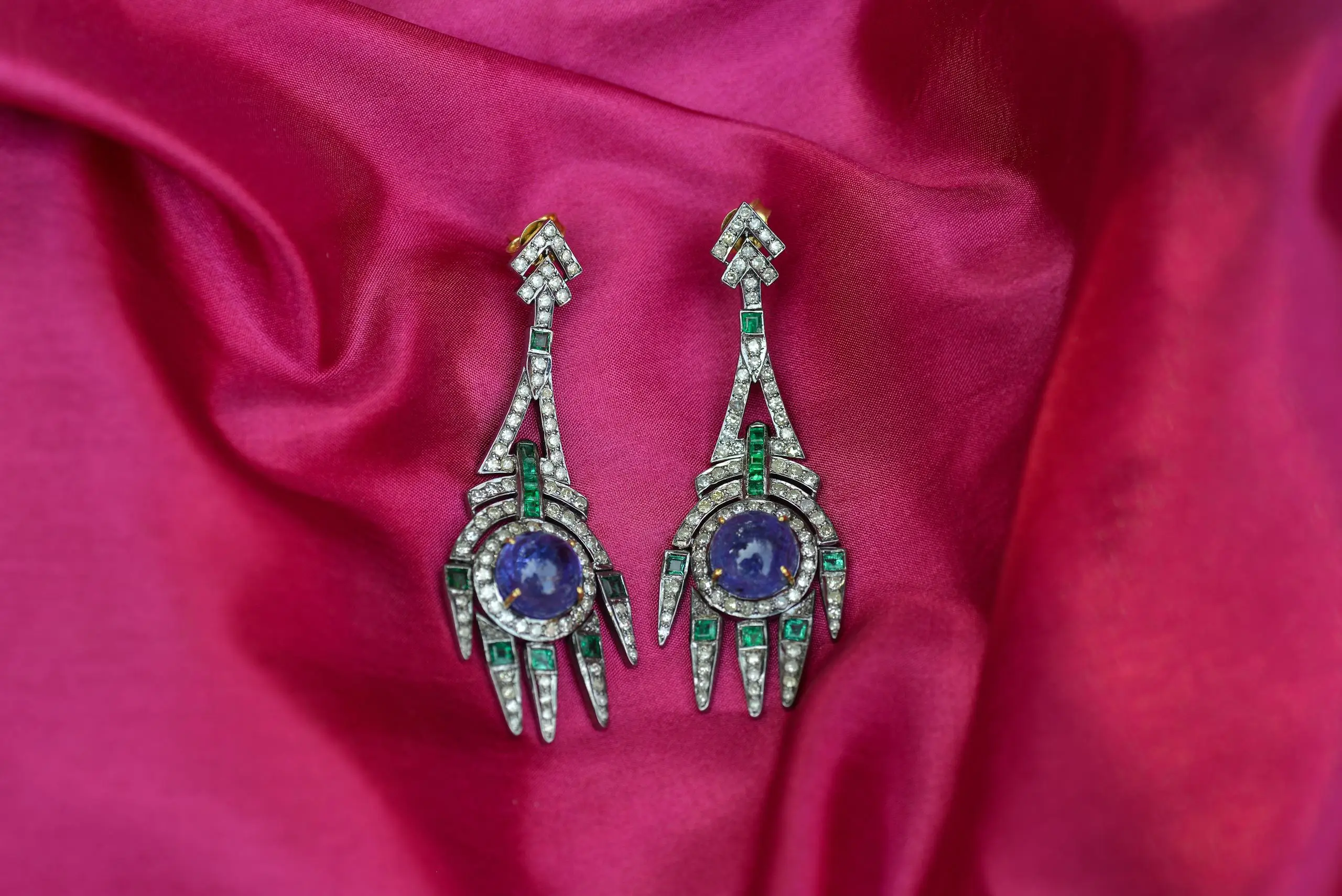 Close-up of luxury earrings with Madagascar and Sri Lanka pink sapphires on vibrant silk background