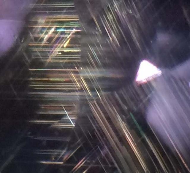 Unheated Madagascar pink sapphire showing sharp, continuous rutile needles with bright, colorful interference under fiber-optic light