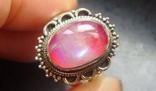 Mounted pink moonstone jewelry with color-backed base, showing enhanced pink shimmer.