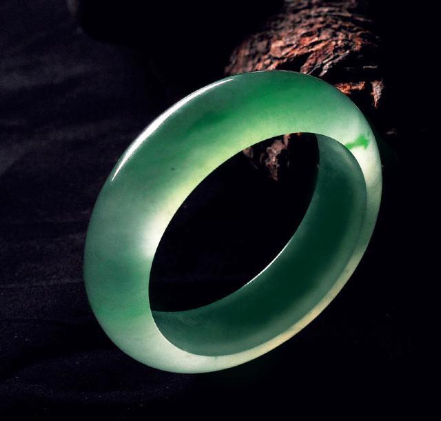 Jade bangle with smooth texture and vibrant green color, a stunning piece of jade jewelry.