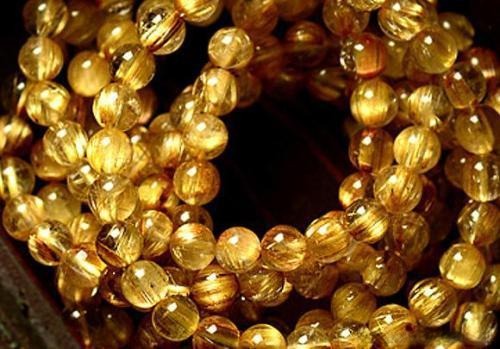 Natural rutilated and phantom quartz bracelet showcasing fine golden rutile needles and ghost-like inclusions within each bead.
