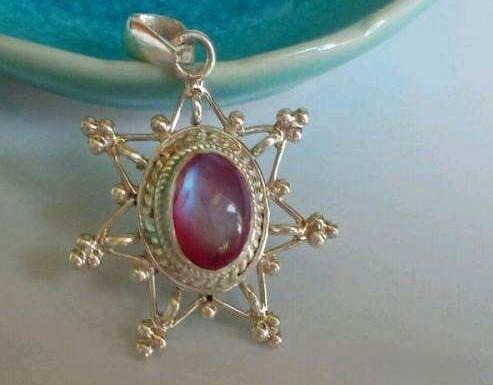 Mounted pink moonstone pendant necklace with color-backed base, showing enhanced pink shimmer – Gemstone Jewelry Buying Tips.