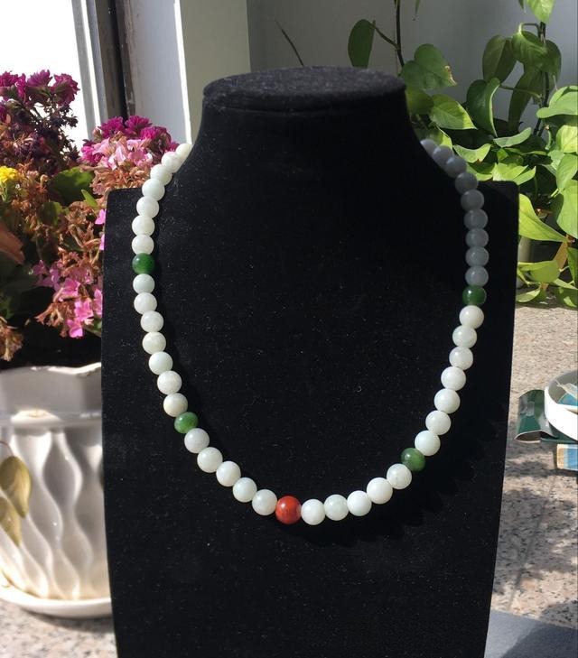 Plain jade bead necklace after jewelry redesign, enhanced with colorful accent beads and a refined clasp for an elegant look.
