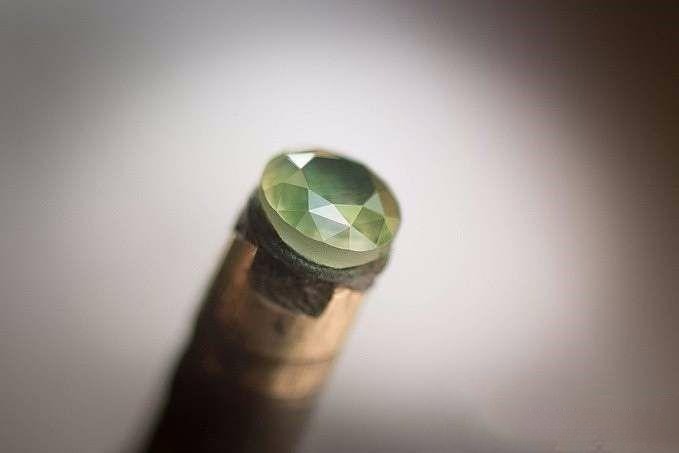 All crown facets polished and completed, showcasing perfect edge alignment and a crystal-clear gemstone with a sparkling, water-like appearance