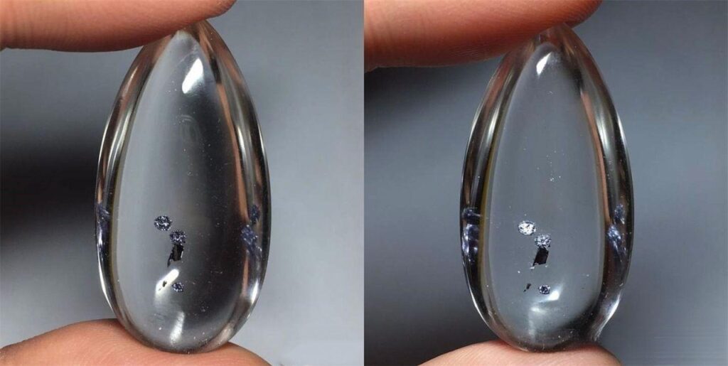 Quartz crystal containing hematite clusters resembling lonely floating planets in a miniature cosmic scene