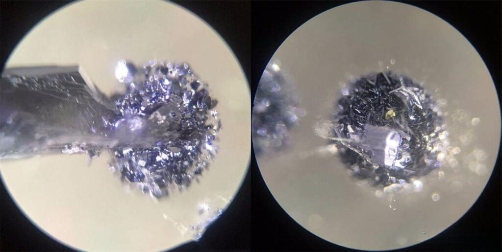 Microscopic view of quartz crystal showing hematite clusters with detailed structure, highlighting their floating and ethereal appearance