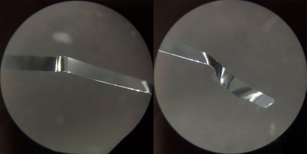 Microscopic view of quartz crystal showing smooth bismuth-lead wire-like inclusions, with a surface polished like mirror, unlike steel wool