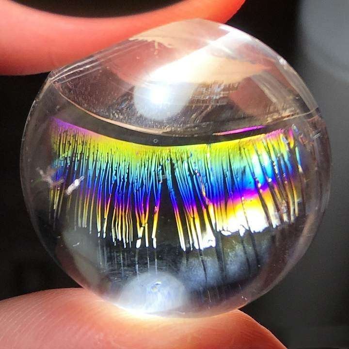 Crystal with rainbow lash inclusions created by tiny stress fractures that diffract light and shimmer like delicate eyelashes