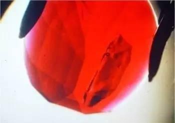 Magnified view of a glass-filled ruby, showing how the filling enhances clarity and conceals fractures.