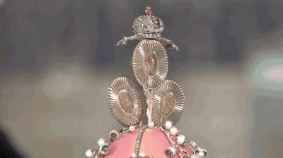 Close-up of Fabergé "Valley of Hundred Flowers" egg showing hidden mechanical miniature portraits of Tsar Nicholas II and his daughters Olga and Tatiana, revealed by twisting a flower stem.