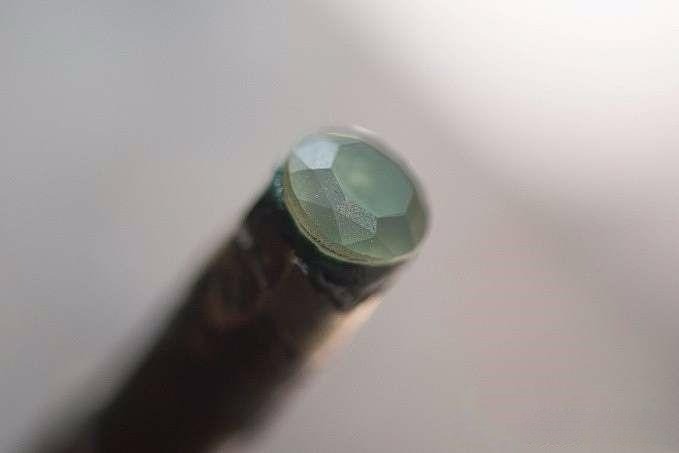 Waist facets completed on the gemstone, with a sandy texture before polishing, showing an unfinished surface