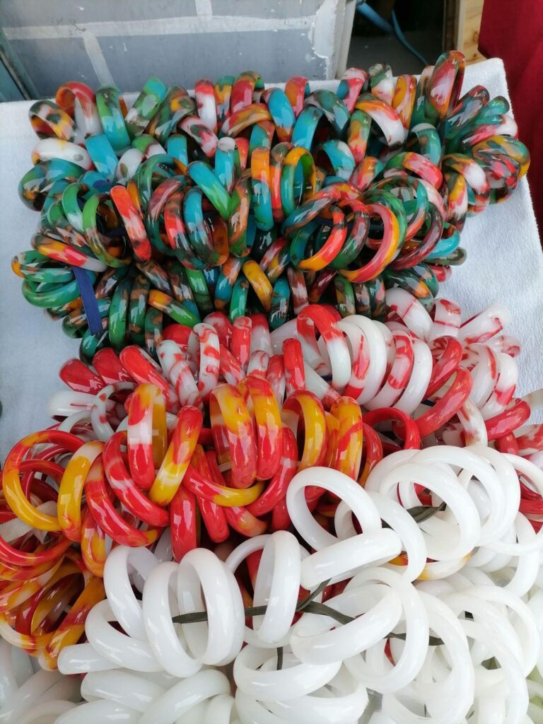 Pile of brightly colored emulsified glass bangles, commonly sold as "Outer Mongolian material" (Wai Meng Liao) in the market.