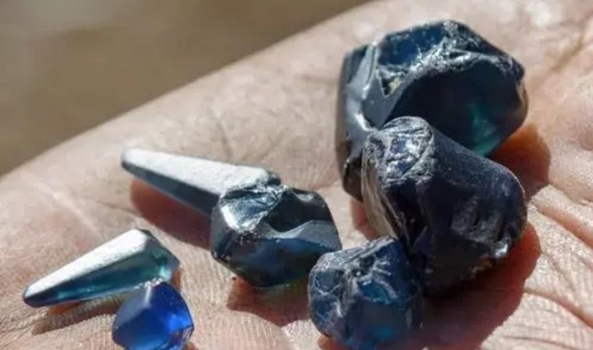 Australian sapphires, known for their high yield but dark colors, often containing dust-like inclusions and distinct color banding.