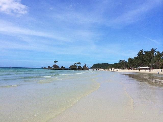 White sand beach and clear waters of Boracay, Philippines, where the gradient blue hues perfectly echo the color of the sea, symbolizing tranquility and beauty.