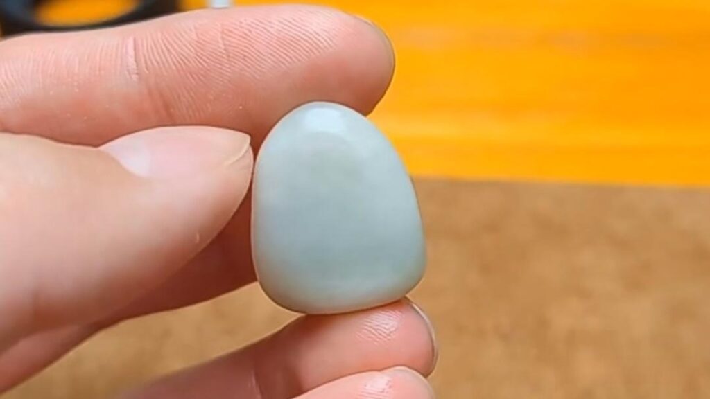 A raw or tumbled piece of diopside mineral, sometimes treated and sold as an imitation of Hetian Jade seed material due to similar color and texture.