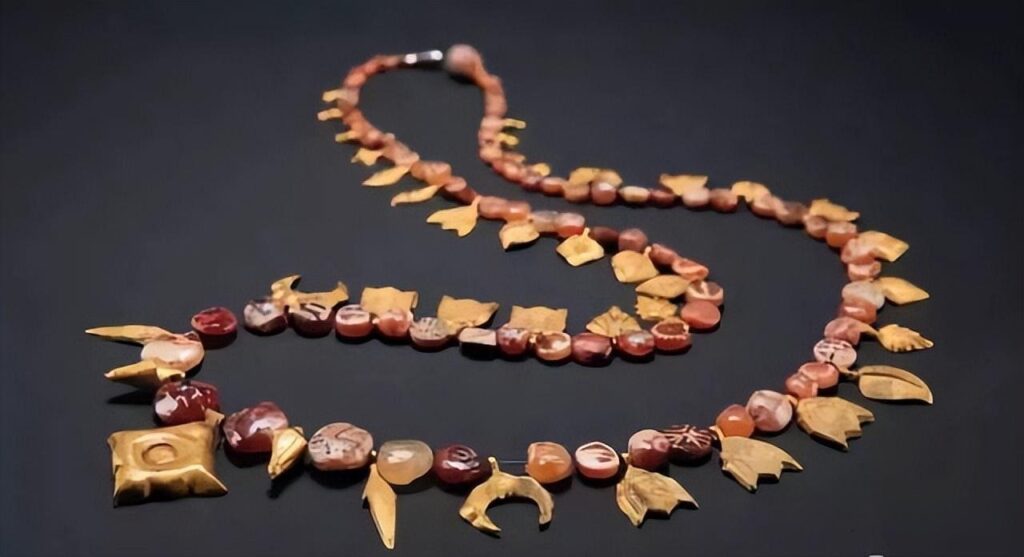 An etched bead necklace paired with gold accents from the British Museum’s collection, representing Indus Valley jewelry and ancient craftsmanship.