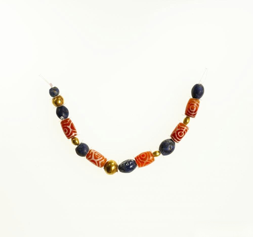 Jewelry featuring etched red agate beads paired with lapis lazuli, showcasing a blend of rich colors and ancient craftsmanship.