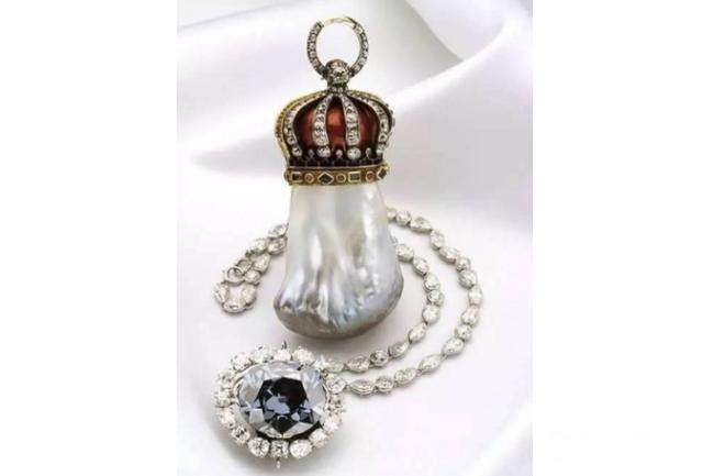 Hope Pearl, an irregular pear-shaped baroque natural saltwater pearl with creamy white and deep brown tones, elegantly mounted in a miniature crown.