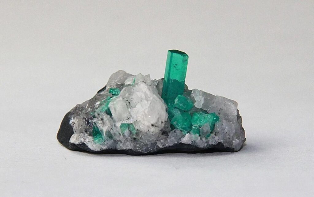 Rough emerald crystals embedded in a white quartz matrix, a characteristic Indian specialty gemstones specimen from the region's mines.