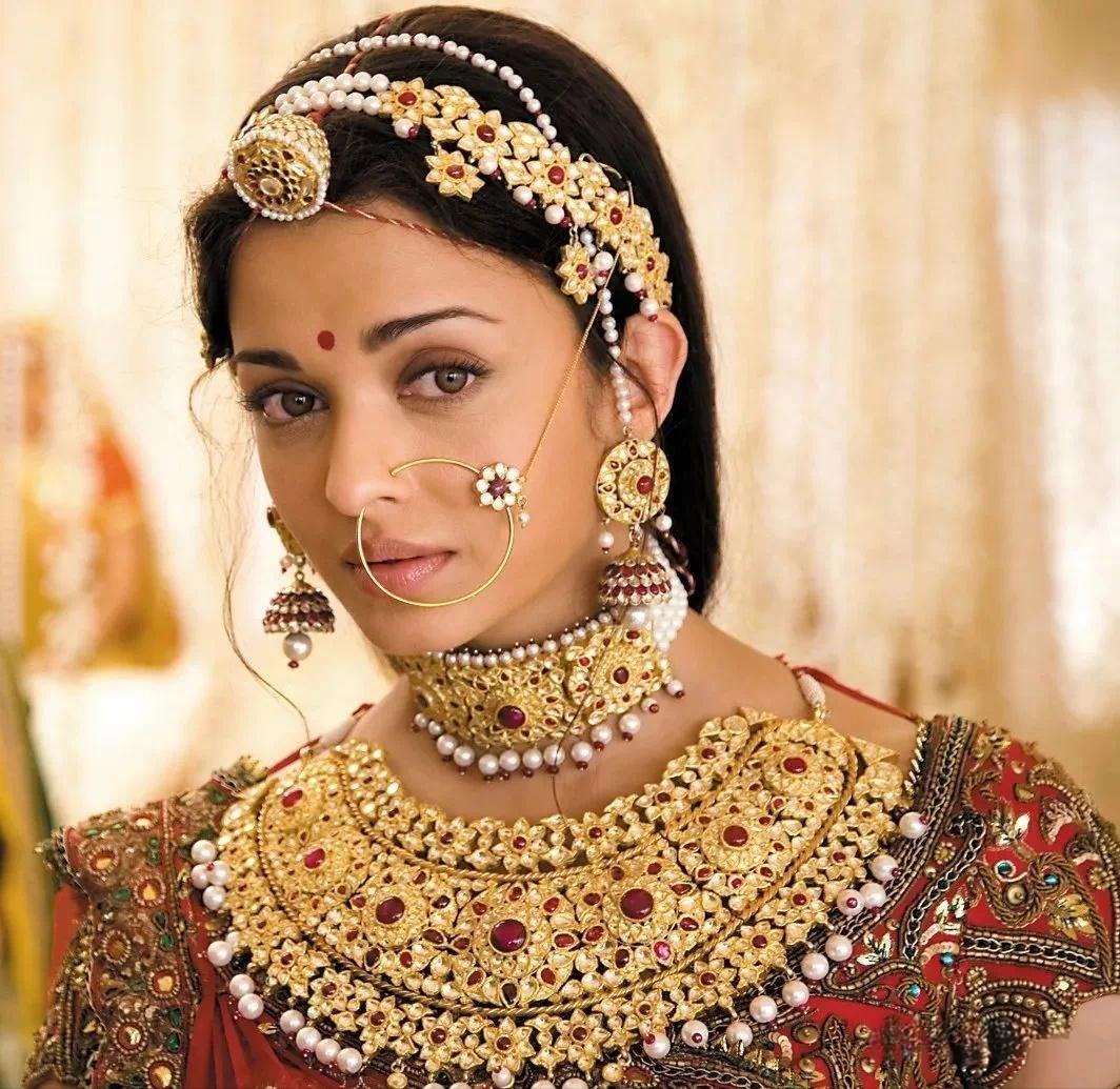 Indian bride adorned in heavy and ornate gold jewelry, showcasing traditional bridal elegance.