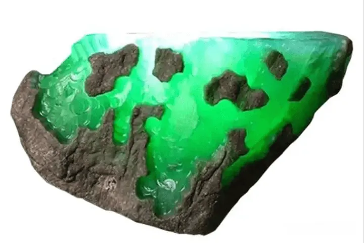 Partially revealed jadeite rough showing some internal color and translucency, with remaining material still unknown.