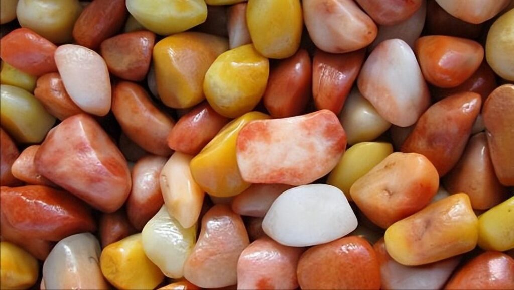 A collection of raw Jinsi Jade (quartz-based stone) rough pieces, showing the material's natural color variations and typical appearance before cutting and polishing.