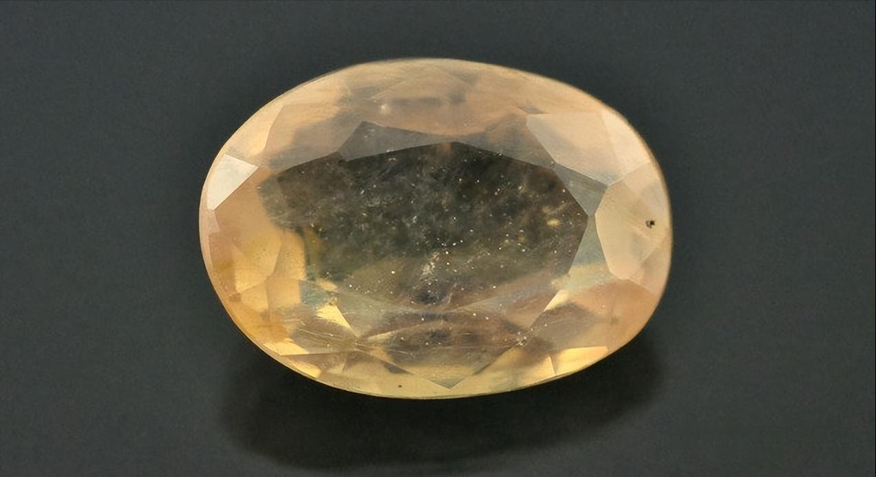 A single yellow sapphire gemstone treated with lead glass filling to enhance its clarity and transparency.