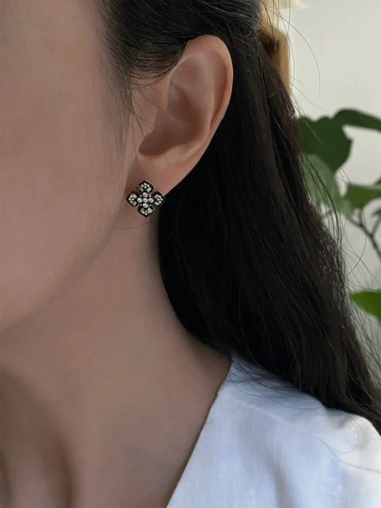 Elegant minimalist silver stud earrings showcased under natural light, highlighting their refined design and subtle everyday charm.