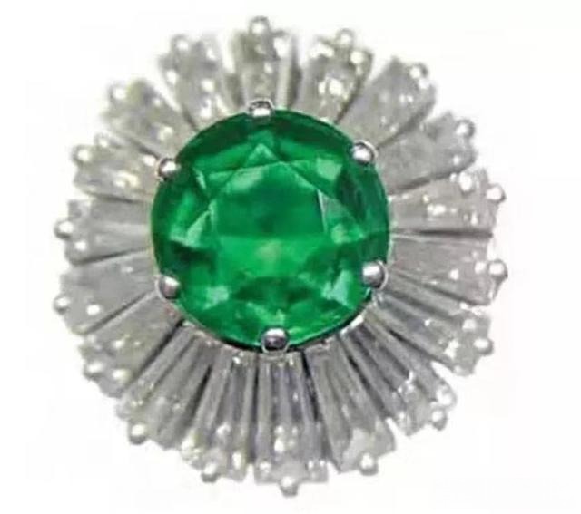 A ring featuring an "Oil Drop" emerald, showing the velvety, luminous appearance caused by the rare Butterfly Effect phenomenon.