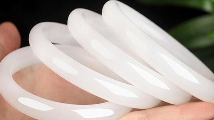 White quartzite bangle bracelet showing a high, glassy polish and vitreous luster.