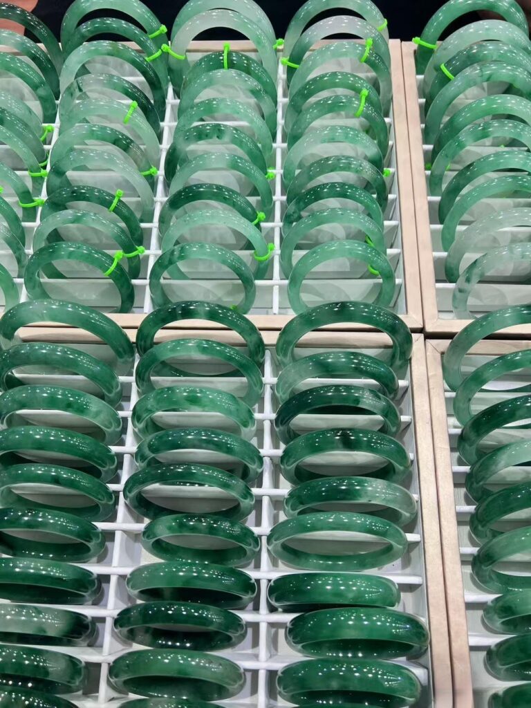 Quartzite jewelry showcased as a jadeite alternative on a display counter, highlighting green tones and craftsmanship.