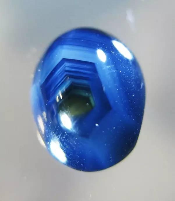 A Chang Le Sapphire viewed with transmitted light, highlighting the distinct internal hexagonal growth bands (color zoning).