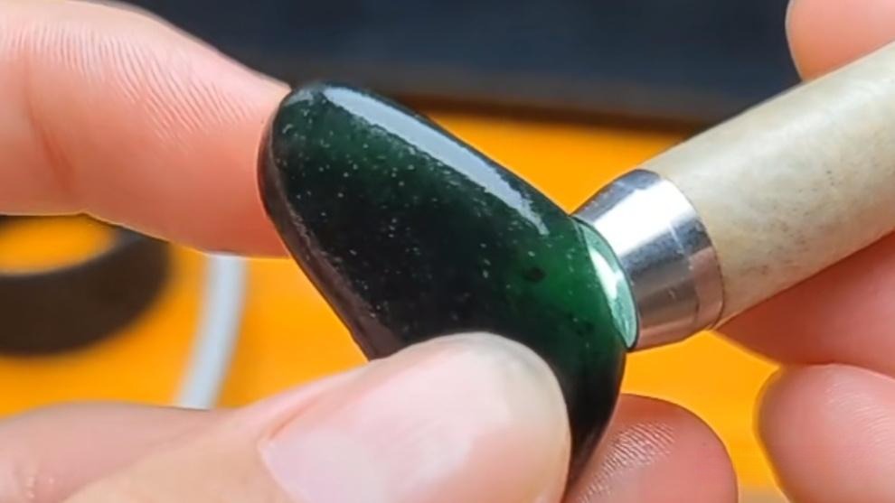 A piece of rough serpentine (serpentinite) stone, often artificially stained and treated to mimic the texture and skin of Hetian Jade seed material.