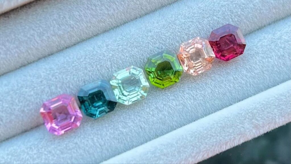 A collection of colorful, highly stable gemstones (such as Tourmaline and Topaz) demonstrating lasting brilliance and stable color, a characteristic ensured by structural water.