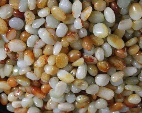 Tumbled jade pebbles with natural skin color, made from low-quality mountain jade cut into small pieces and polished in a tumbling drum.