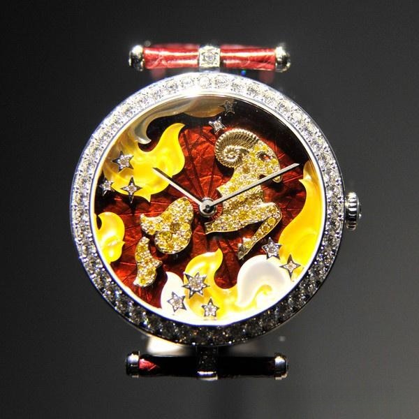 Close-up of the Van Cleef & Arpels Aries zodiac watch dial with vibrant red enamel, adorned with gold, mother-of-pearl, and diamonds