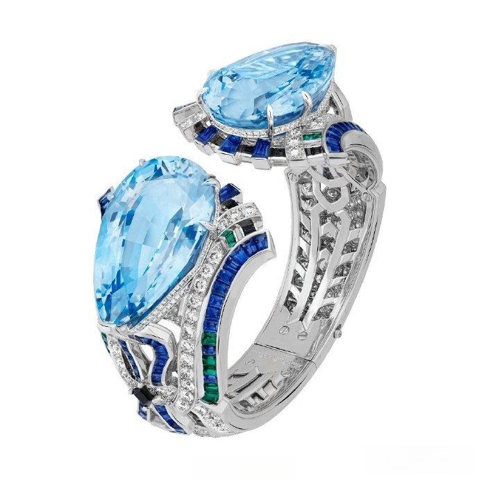 The magnificent "Fiore" Aquamarine and platinum bangle by Van Cleef & Arpels, showcasing a large, brilliantly clear blue gemstone.