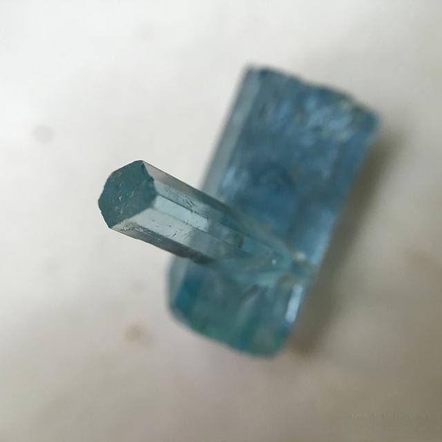 Heated aquamarine rough from Vietnam displaying a geniculated twin crystal structure, valued highly for its rare, unique formation and outstanding visual appeal.
