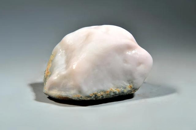 Unpolished rough stone of white Dushan Jade (Bai Du Yu), displaying milky white and semi-translucent tones.
