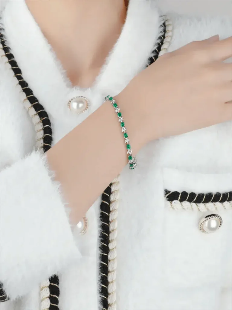 A custom-designed Jewea bracelet featuring natural emeralds set in 18k gold with accent natural diamonds.