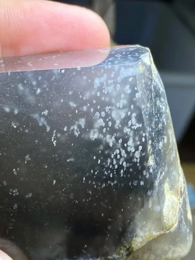 A close-up view of Albite Jade showing its distinct, easily visible granular (sugar-like) structure and cloudy inclusions.